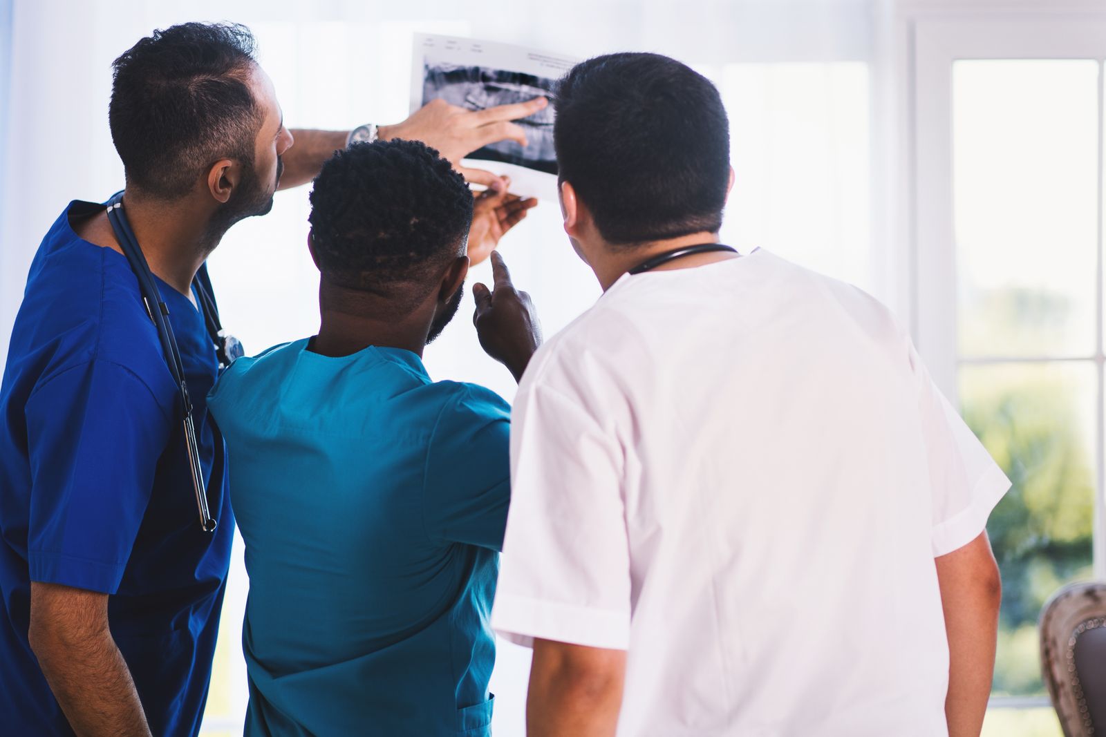 Clinicians reviewing an imaging result together by a bright window