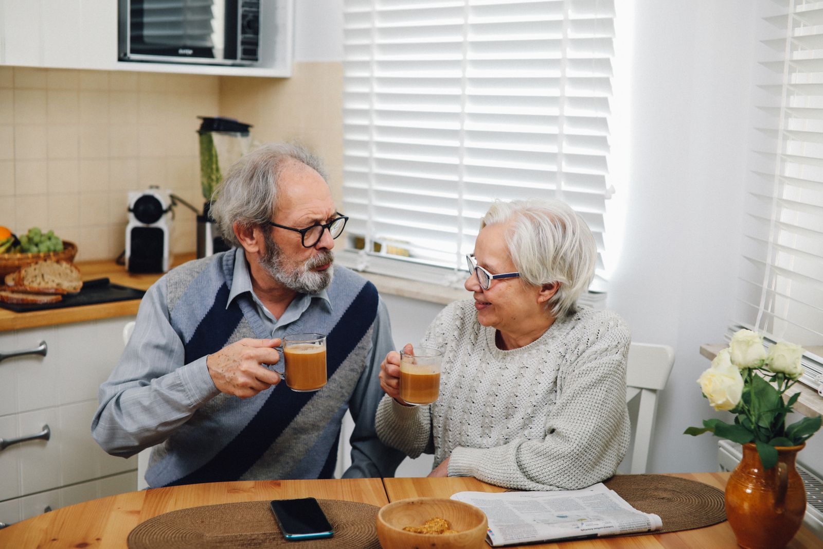 An older couple having morning coffee together at their kitchen table