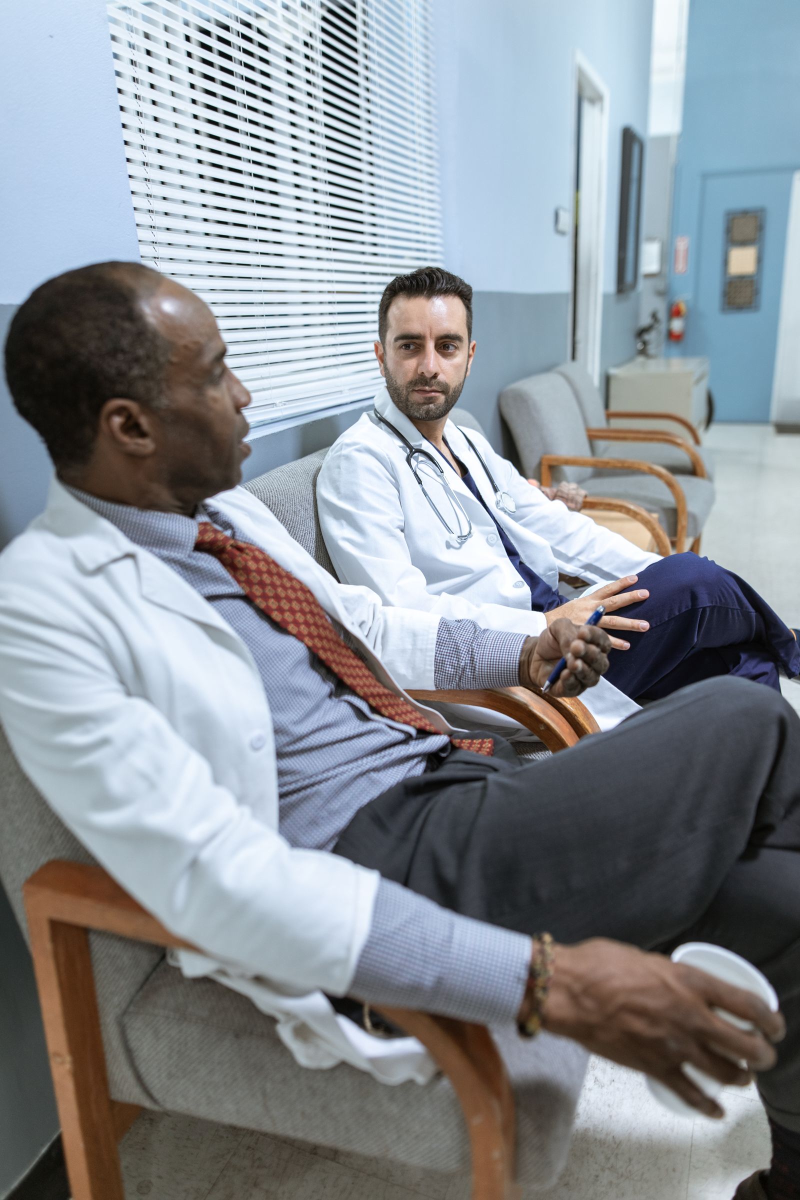 Two physicians in conversation between patient visits